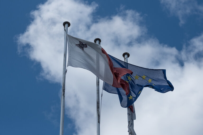 Maltese and European flags are seen in front of the building of the Public Broadcasting Service, Malta's National Television in Pieta, Malta, on October 14, 2020.