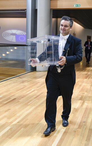 Fotogrāfija 1: Usher carrying a ballot box for the EP President election
