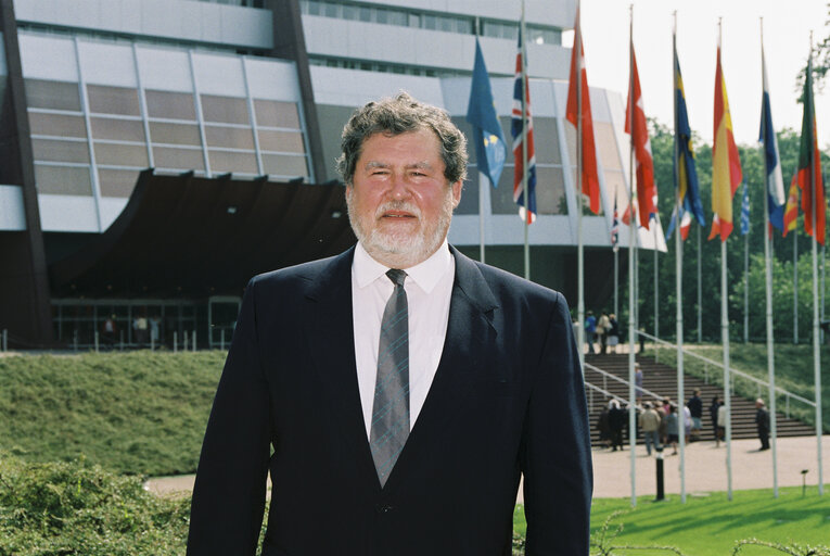 Poprtrait of Claude A F DELCROIX in front of the flags at the EP in Strasbourg