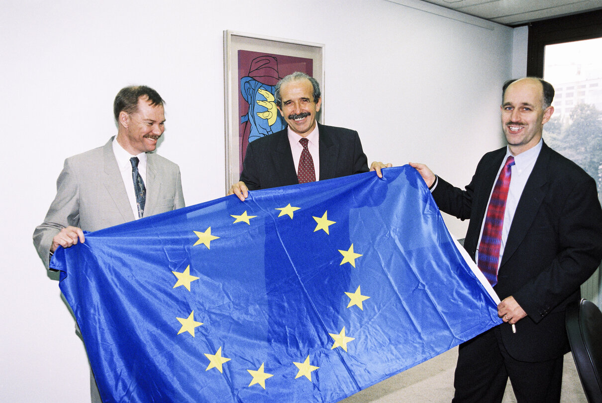 MEPs Renzo IMBENI and Peter SKINNER offer a European flag to a guest