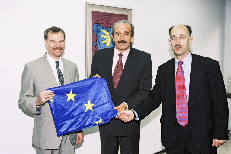 MEPs Renzo IMBENI and Peter SKINNER offer a European flag to a guest