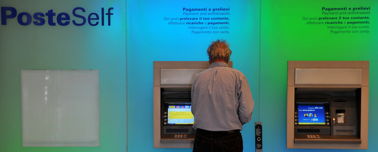 Снимка 3: A man take money in the cash machine at the office of 'Poste Italiane' in Rome