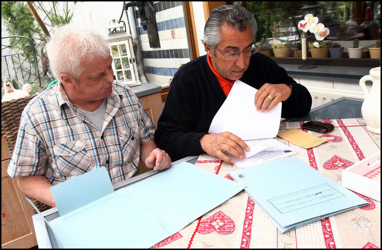 Fotografie 10: A former carpenter with respiratory cancer who can no longer work shows his health dossier.