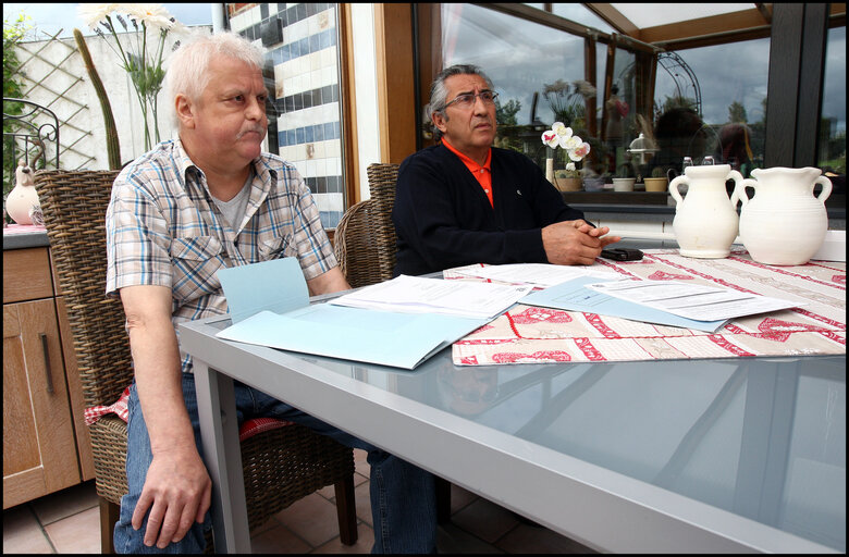 Fotografie 6: A former carpenter with respiratory cancer who can no longer work shows his health dossier.