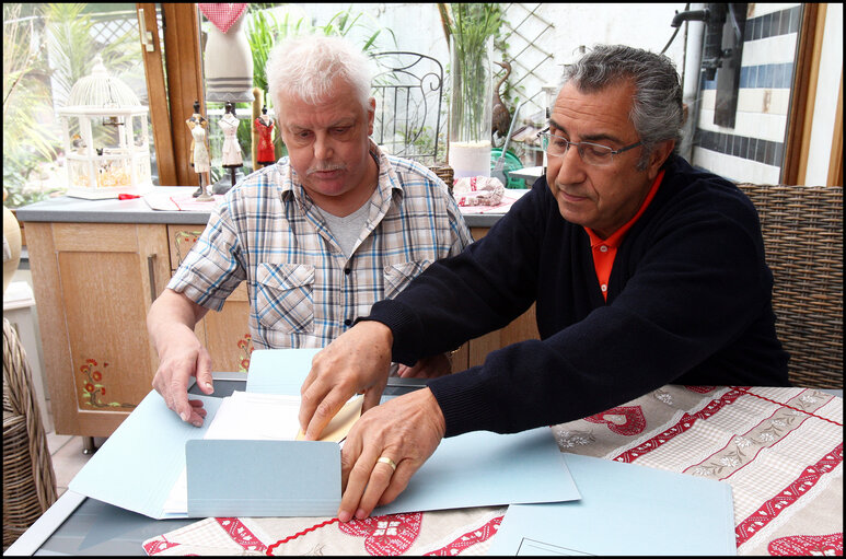 Fotografie 11: A former carpenter with respiratory cancer who can no longer work shows his health dossier.