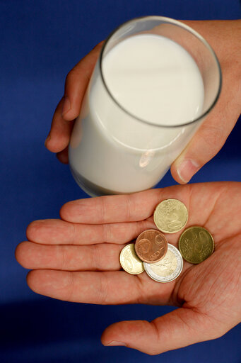 Fotografie 4: Man holding Euro coins and a glass of milk