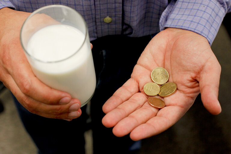 Foto 6: Man holding Euro coins and a glass of milk