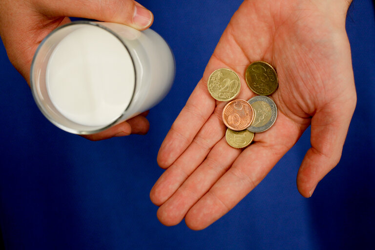 Man holding Euro coins and a glass of milk