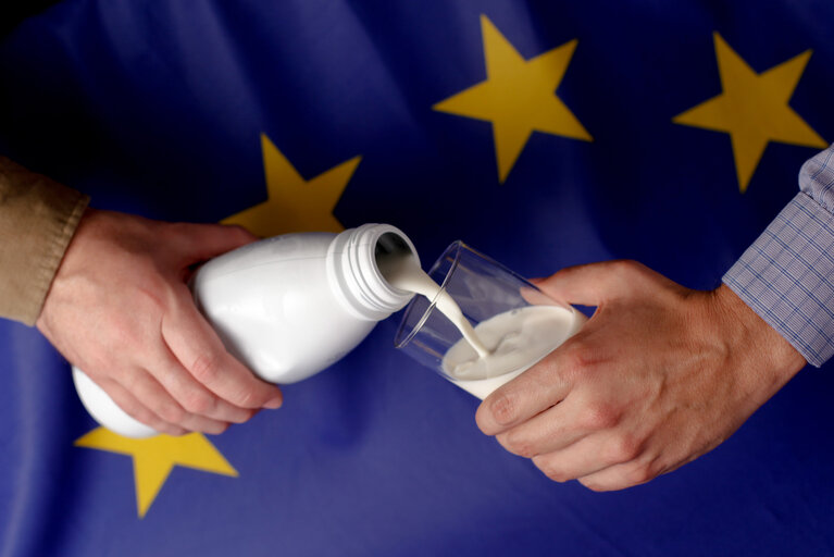 Zdjęcie 10: Man pouring milk in front of a European flag