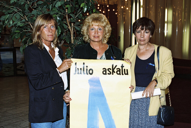 Fotografija 2: Barbara DUHRKOP, Nicole PERY, Ana MIRANDA DE LAGE with blue ribbons, symbol of protest against the Basque separatist organisation Eta and a poster.