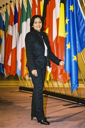 Fotagrafa 13: Portrait of a MEP in front of the flags at the entrance of the Parliament