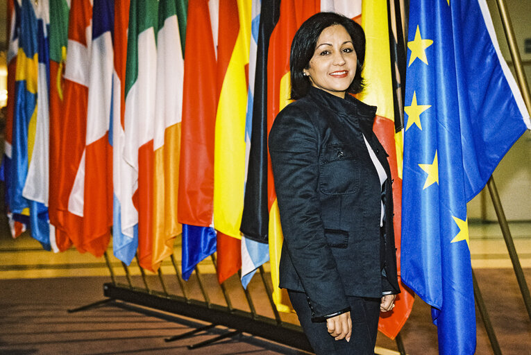 Fotagrafa 11: Portrait of a MEP in front of the flags at the entrance of the Parliament